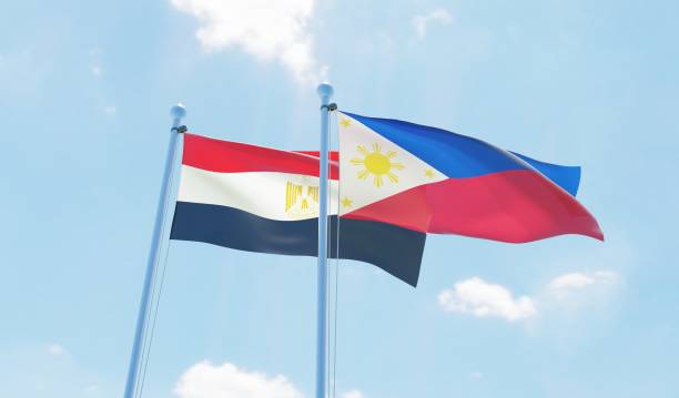 istock Philippines and Egypt, two flags waving against blue sky 1129648598