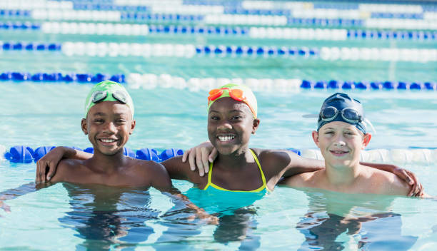 istock Multi-ethnic children in swimming pool smiling at camera 1129649798