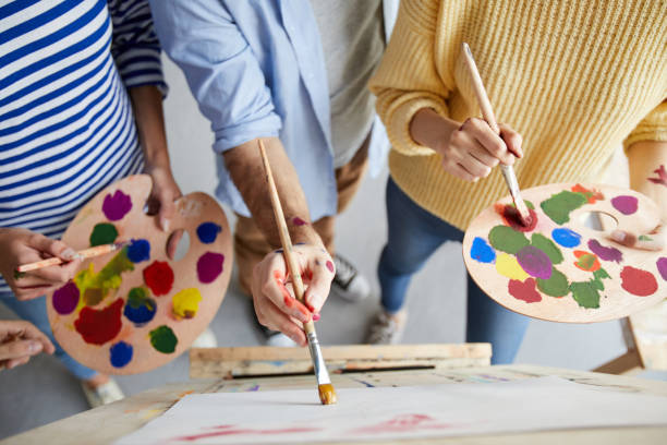 Painting with colors Overview of man with paintbrush teaching his students with color palette how to paint professionally art workshop stock pictures, royalty-free photos & images