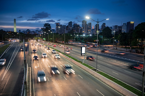 Dark and moody image of urban road with traffic at twilight