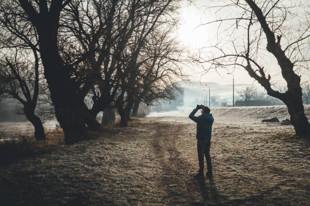 istock Ornithologist looking through binoculars in forest. Bird watching 1129650881