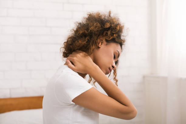 mujer que sufre de dolor de cuello, despertar en la mañana - neck pain fotografías e imágenes de stock