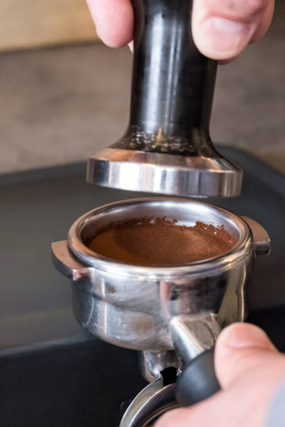istock Tamper over fresh tamped coffee in portafilter to making espresso 1129651895