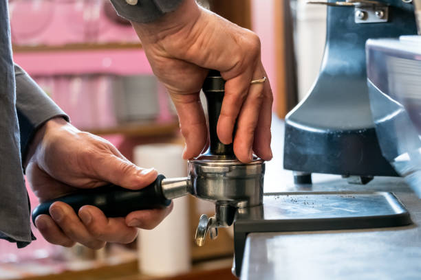 istock Barista pressing coffee with tamper in portafilter to making espresso 1129651900