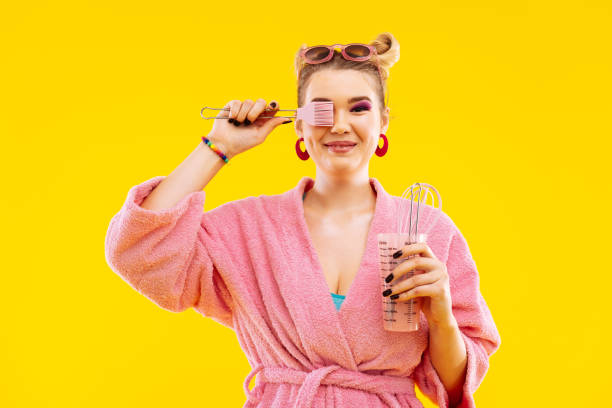 istock Housewife wearing bathrobe holding kitchen utensils before cooking 1129652843