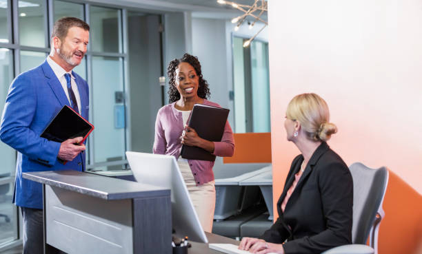 istock Business people in an office talking to receptionist 1129653223