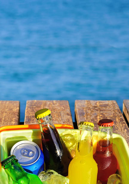 istock Cold soda drinks on the wooden beach pier and blue sea. 1129654130