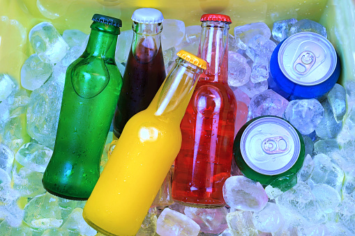 Coloridas bebidas gaseosas y cubitos de hielo rellenos en una nevera photo