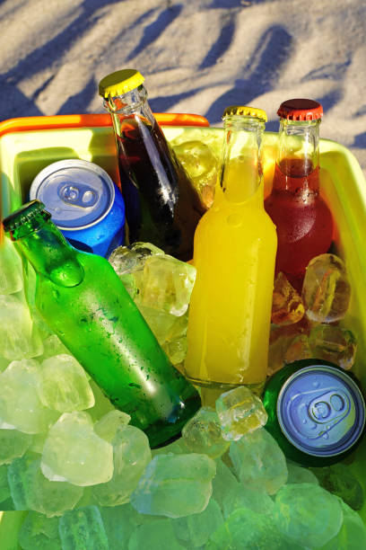 istock Colorful soda drinks and filled ice cubes in a coolbox on the beach sand. 1129655554