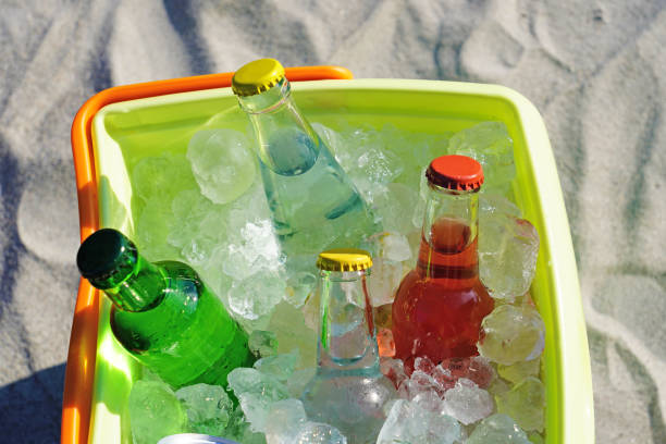 istock Glass bottle soda drinks and filled ice cubes in a coolbox on the beach sand. 1129655587