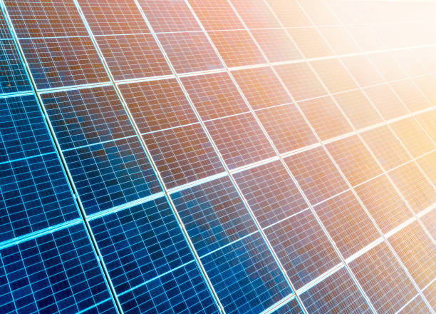 close-up surface of lit by sun blue shiny solar photo voltaic panels. system producing renewable clean energy. renewable ecological green energy production concept. - voltaic imagens e fotografias de stock