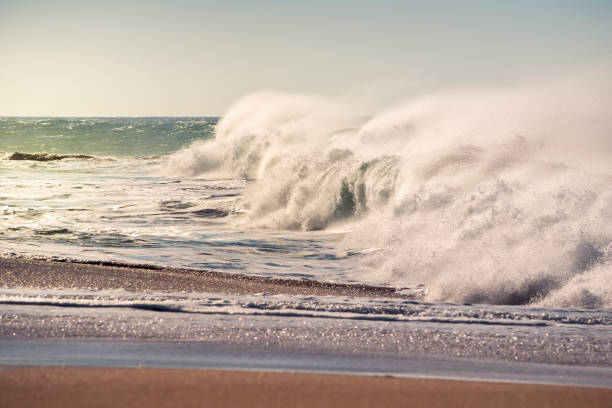 istock Big wave breaking on the shore with lots of foam 1129661535