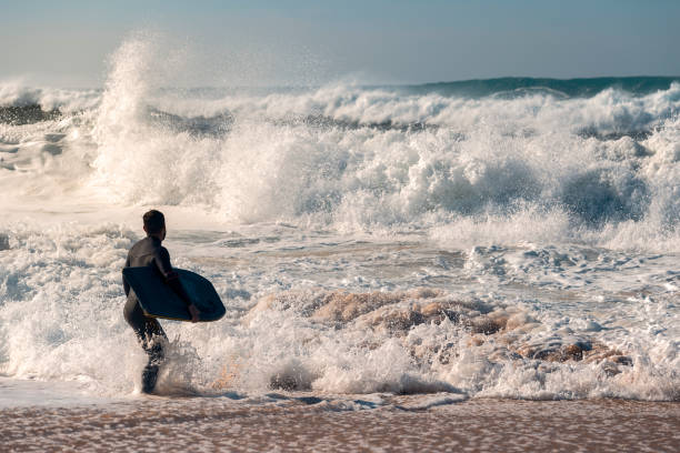 istock Surfer faces the challenge of a powerful rough sea 1129661544