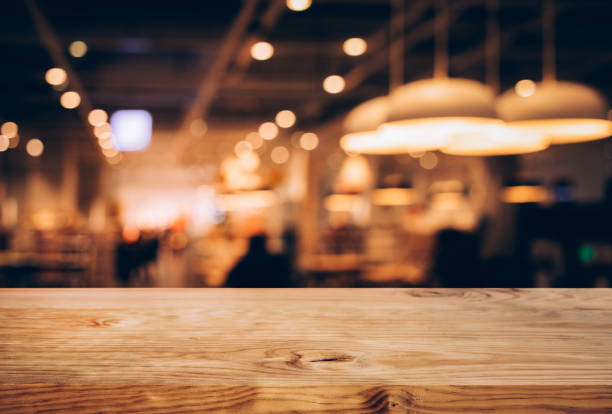 木材紋理桌面 (櫃檯酒吧) 與模糊的光黃金 bokeh 在咖啡館, 餐廳背景。用於蒙太奇產品展示或設計關鍵視覺 - 吧 公共飲食地方 圖片 個照片及圖片檔