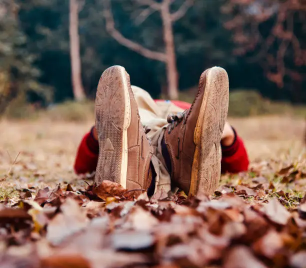 Photo of Isolated shoes of a lying man on the ground