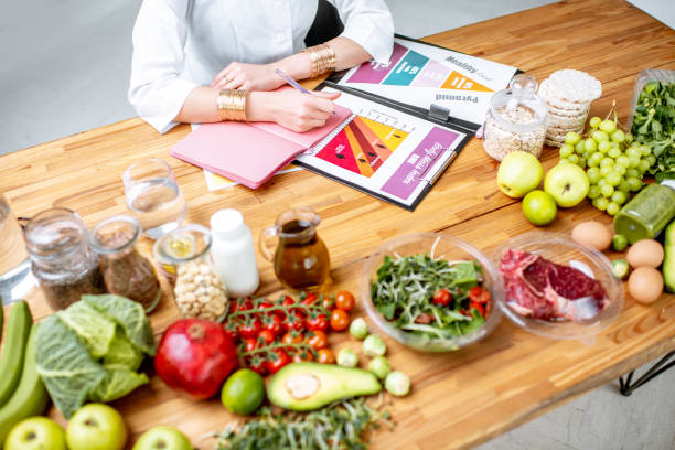 istock Writing a diet plan on the table full of healthy food 1129664450