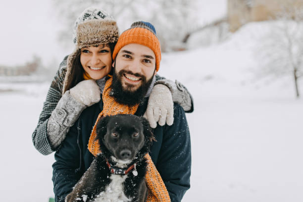 istock Couple in the snow play with dog 1129664487