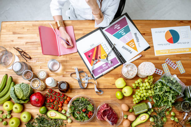 istock Writing a diet plan on the table full of healthy food 1129664590