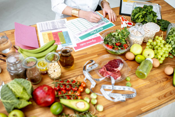 istock Writing a diet plan on the table full of healthy food 1129664848