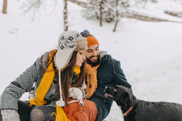 istock Couple in the snow play with dog 1129665124