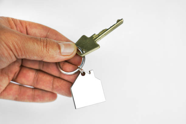 istock Handing over key with house shape key ring. 1129665997