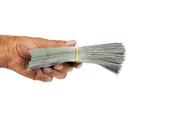 istock Man holding handful banknotes tied with a rubber band on white background. 1129666033