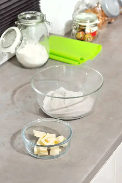 Food products butter and flour stand on the kitchen counter in glass containers.