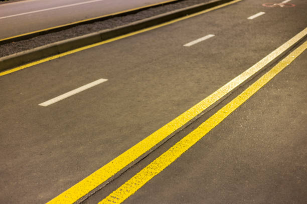 istock Wide bright double yellow marking sign line along modern wide smooth empty asphalt highway street stretching to horizon. Speed, safety, comfortable journey and professional road building concept. 1129666185