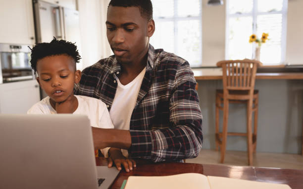 istock African American father and son using laptop at table 1129666333