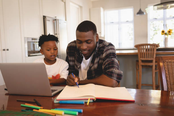 istock African American father helping his son with homework at table 1129666349