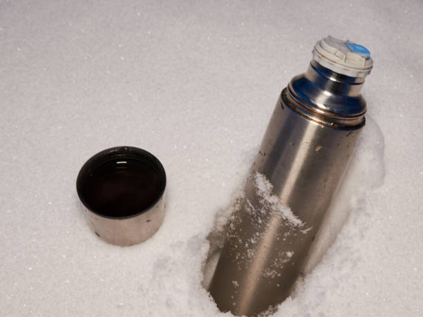 istock A large silver metal tea thermos with an open lid is standing in a snowdrift. winter cold evening forest 1129667569