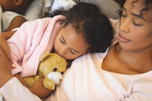 istock African American mother and daughter sleeping together 1129668996