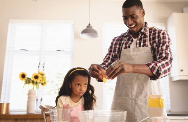 istock African American father and daughter baking cookies in kitchen 1129669270