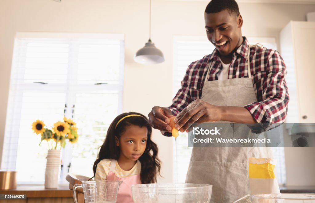 African American father and daughter baking cookies in kitchen Front view of African American father and daughter baking cookies in kitchen at home 30-39 Years Stock Photo