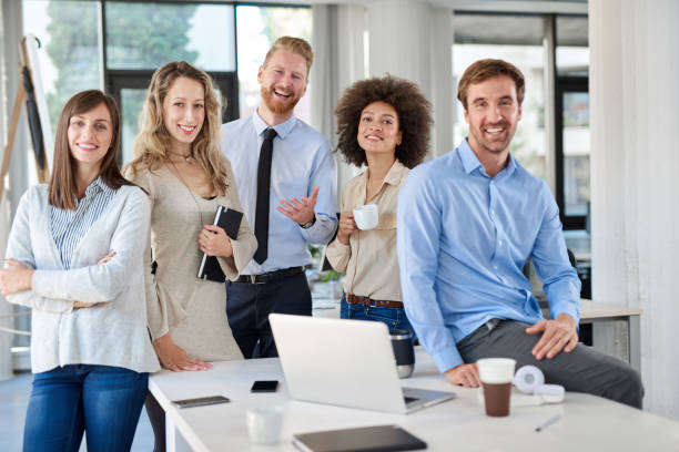 istock Cheerful group of business people posing in office. 1129669448