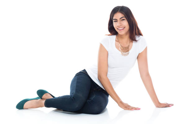 istock Beautiful latino female sitting on a white floor 1129669562