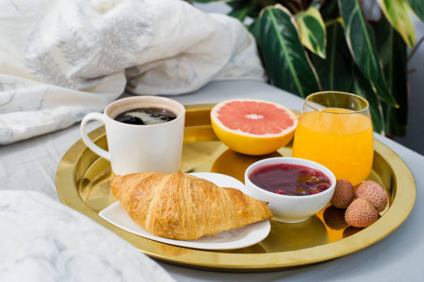 istock French Breakfast, hotel service. Coffee, jam, croissant, orange juice, grapefruit, lychee. Side view 1129669632
