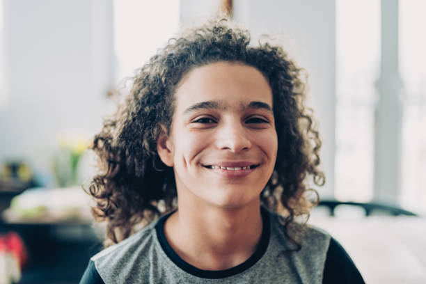 Curly teen laughing Portrait of a smiling young boy 14 15 years stock pictures, royalty-free photos & images