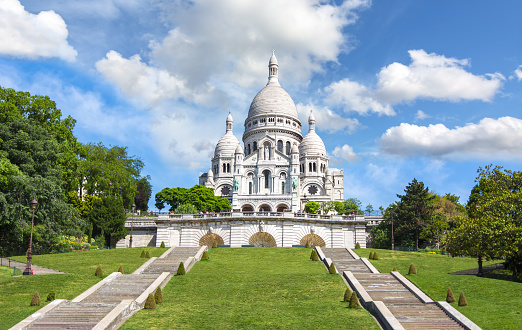 View of the Sacré-Coeur Basilica de Montmartre with clear blue sky - Paris, France. The Sacré-Cœur Basilica de Montmartre (Sacred Heart of Montmartre) is a Roman Catholic church and minor basilica in Paris dedicated to the Sacred Heart of Jesus. It was formally approved as a national historic monument by the National Commission of Patrimony and Architecture on December 8, 2022. It is located at the summit of the butte of Montmartre. From its dome two hundred meters above the Seine, the basilica overlooks the entire city of Paris and its suburbs. It is the second most popular tourist destination in the capital after the Eiffel Tower.\nThe porch of the south façade is topped with a statue representing the Sacred Heart of Christ.