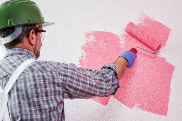 istock Professional house painter at work painting the wall 1129670802