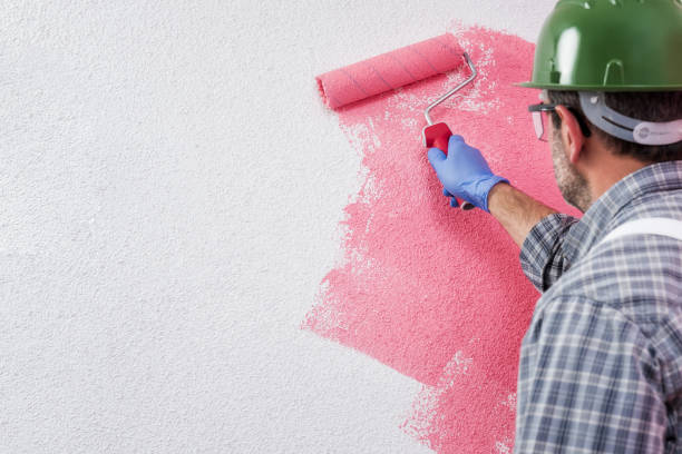 istock Professional house painter at work painting the wall 1129670806