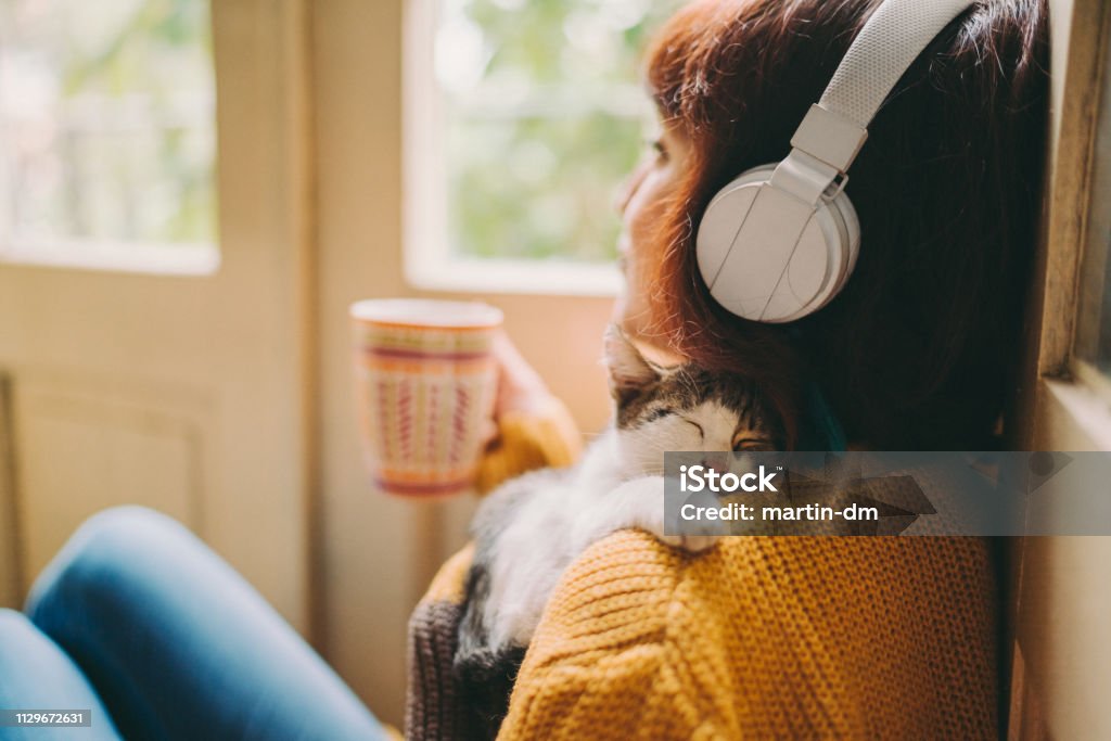 Cozy home Woman at home listening to music and drinking coffee Music Stock Photo