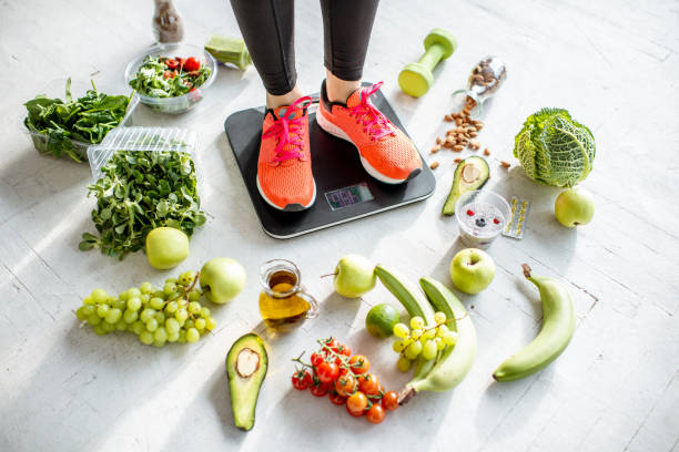 https://media.istockphoto.com/id/1129673037/photo/sports-woman-weighing-with-healthy-food-around.jpg?s=612x612&w=0&k=20&c=XmWfRrLdmL2pnlDLUCdaOMPxnMacb7sendwt6l6n7HU=