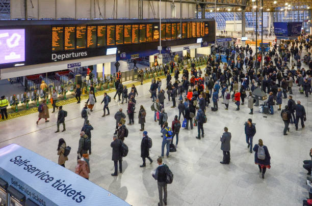 molte persone di fronte al tabellone dell'ora di punta alla stazione ferroviaria di waterloo, londra, inghilterra.stazione di waterloo, un capolinea ferroviario nel centro di londra - london england on the move commuter rush hour foto e immagini stock