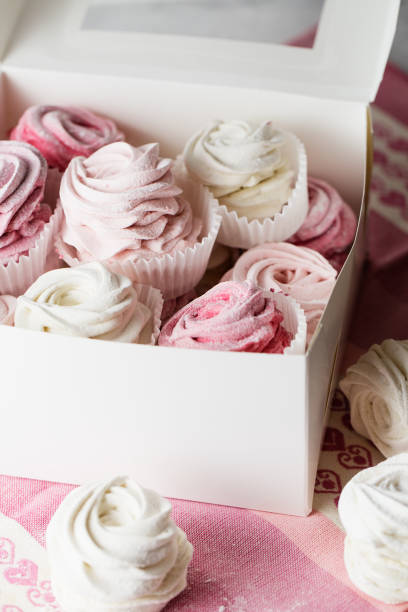 istock Sweet dessert zephyr marshmallows close up. Big zephyr sprinkled with powdered sugar. Valentine's Day concept 1129673837