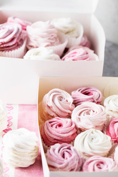 istock Sweet dessert zephyr marshmallows close up. Big zephyr sprinkled with powdered sugar. Valentine's Day concept 1129673859