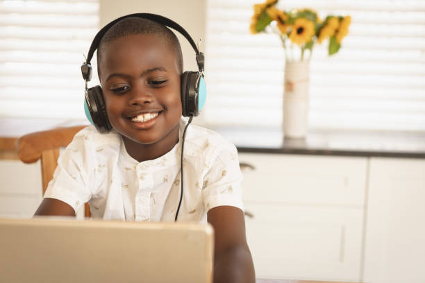 istock African American boy playing game on digital tablet at dining table in kitchen 1129673860