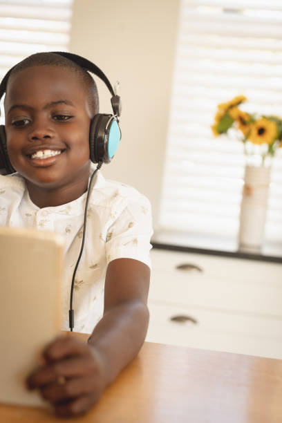 istock African American boy playing game on digital tablet at dining table in kitchen 1129673874