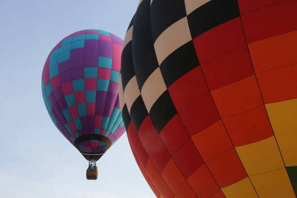 istock A hot air balloon inflates while a second flies past in the background. 1129674982
