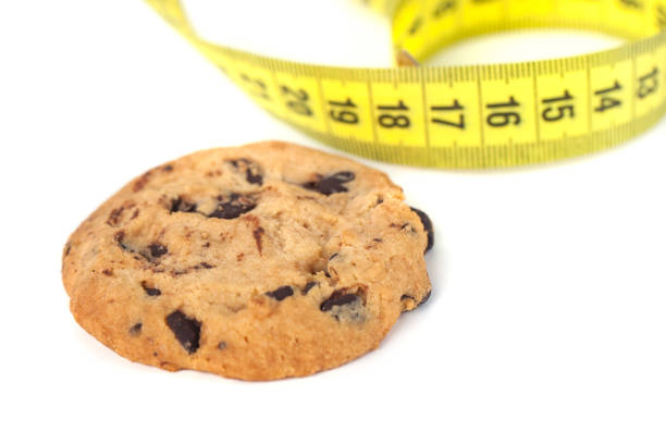 istock Chocolate Chip Cookie  with Measuring Tape Isolated on White, Diet Concept 1129675502